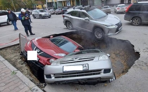 Две машины провалились под землю в Новосибирске из-за аварии на теплотрассе. Видео с места происшествия